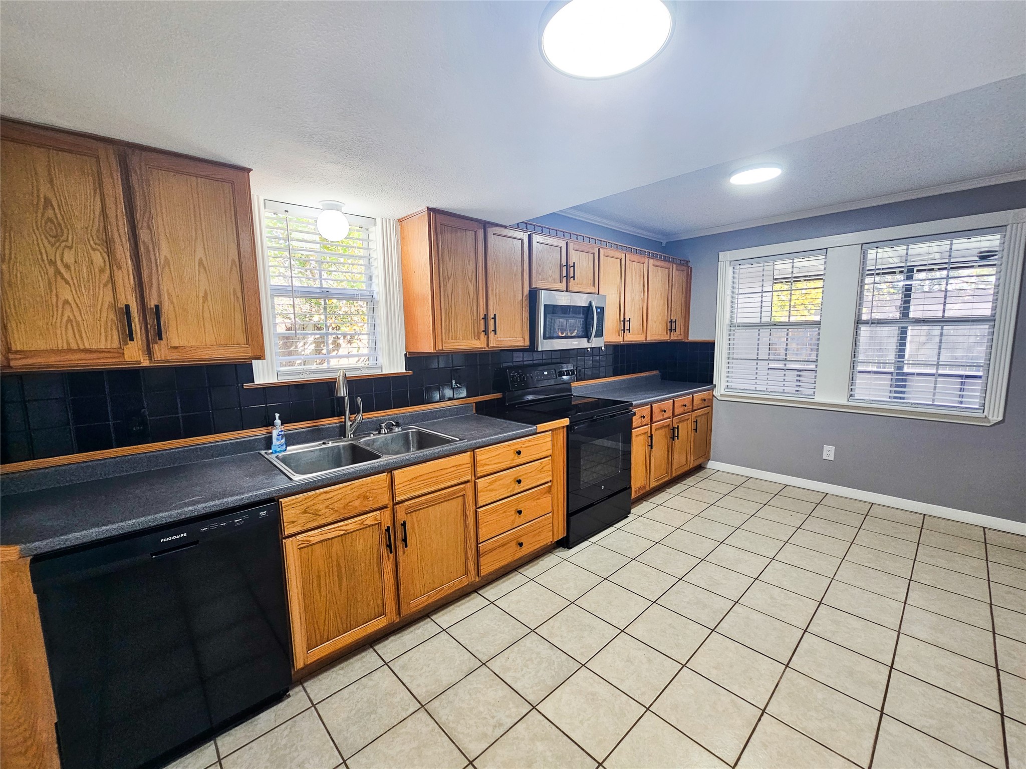 108 Oriole Lane Angleton, TX 77515 - Photo 10 of 20 a large kitchen with granite countertop a stove a sink a window and dining table