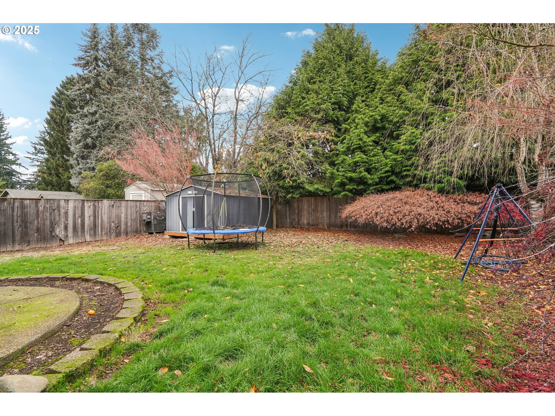 858 Northeast 166th Avenue Portland, OR 97230 - Photo 14 of 17 a view of a backyard with large trees and wooden fence
