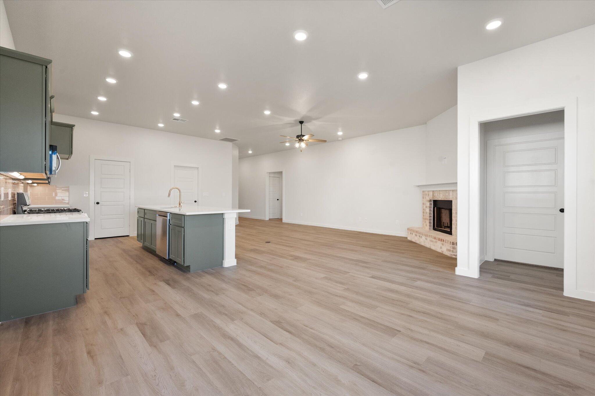 7004 16th Street Lubbock, TX 79416 - Photo 12 of 25 a open kitchen with kitchen island a sink dishwasher stove with wooden floors