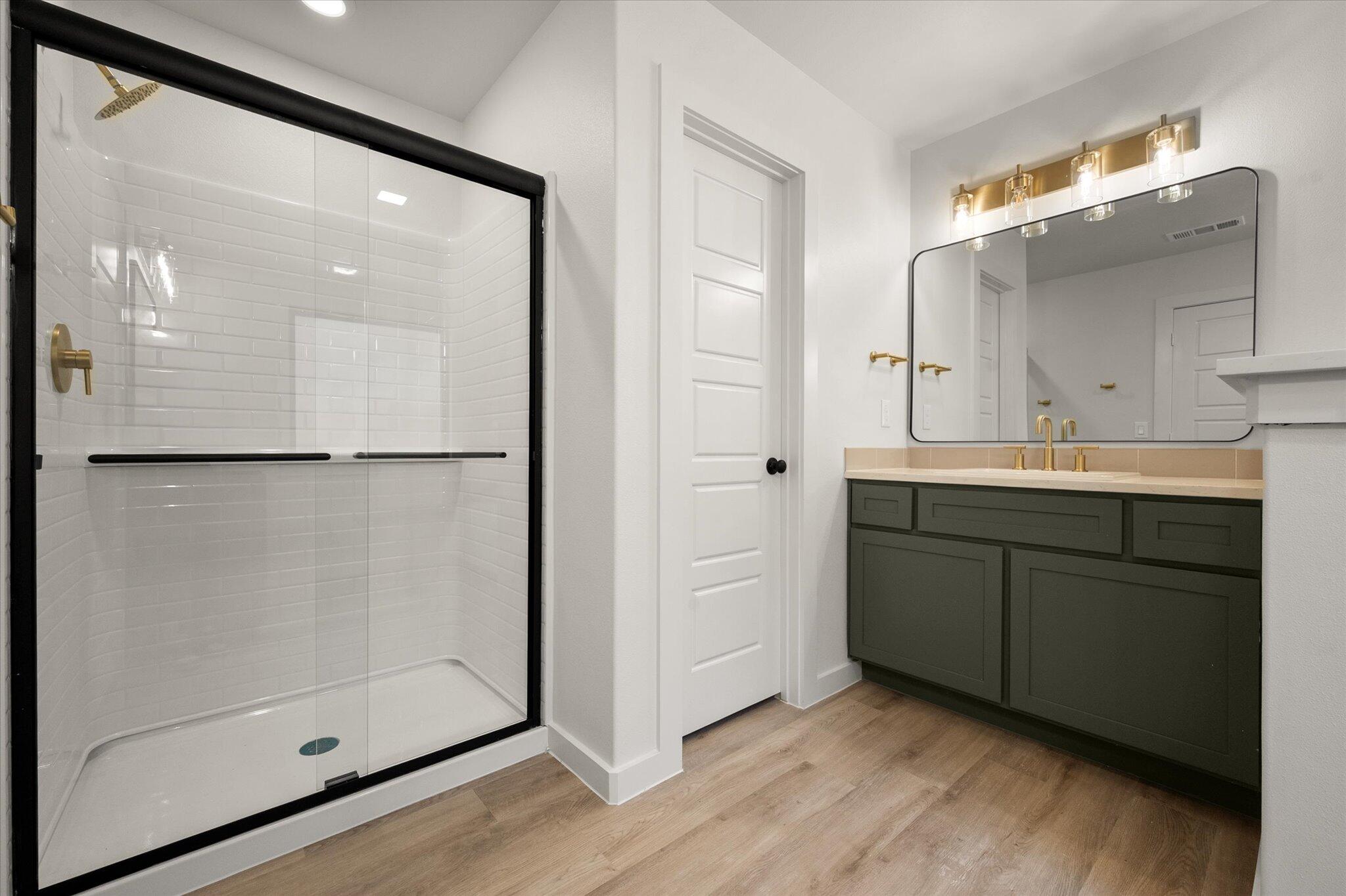 7004 16th Street Lubbock, TX 79416 - Photo 17 of 25 a bathroom with a shower sink and mirror