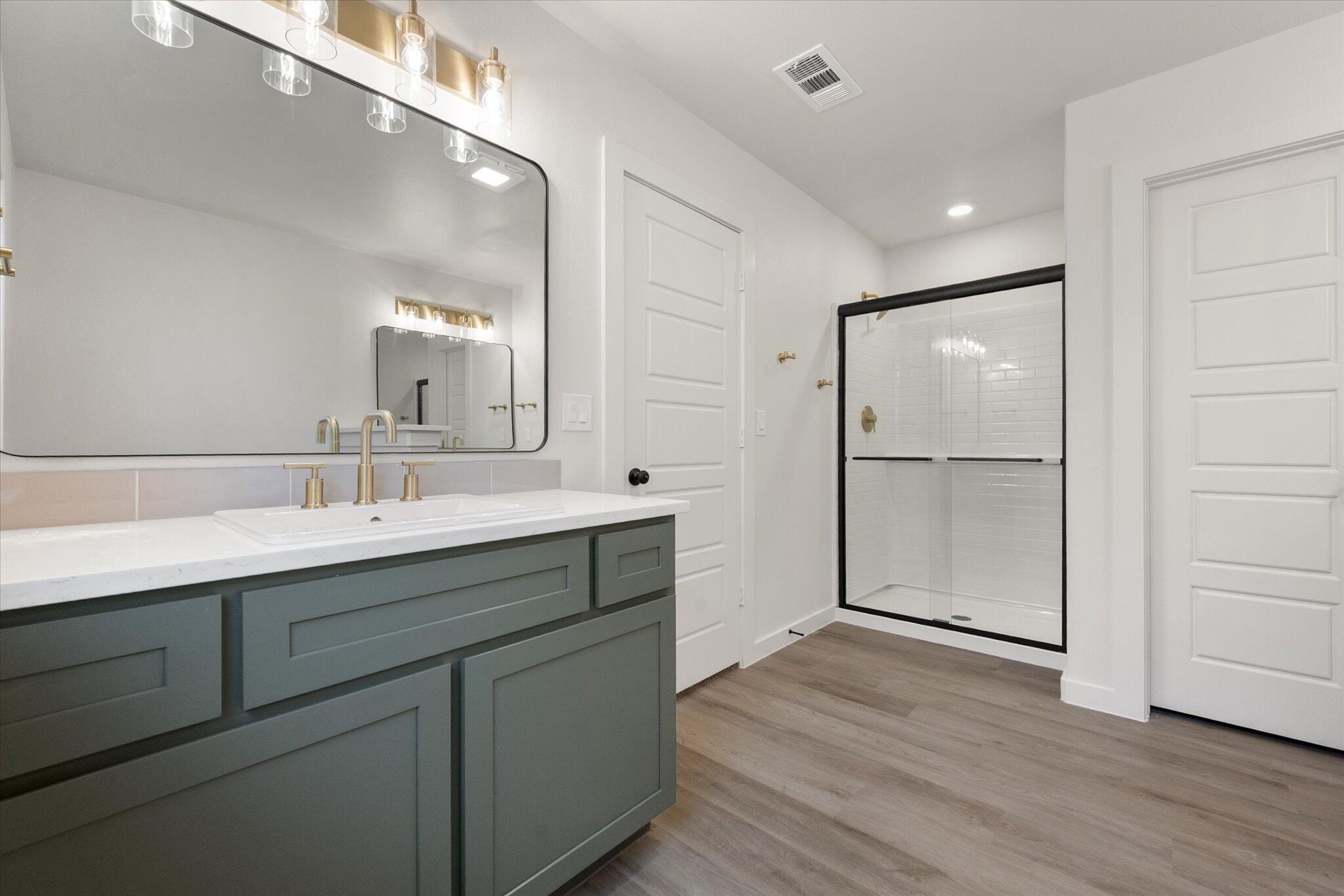 7004 16th Street Lubbock, TX 79416 - Photo 18 of 25 a spacious bathroom with a shower sink and mirror