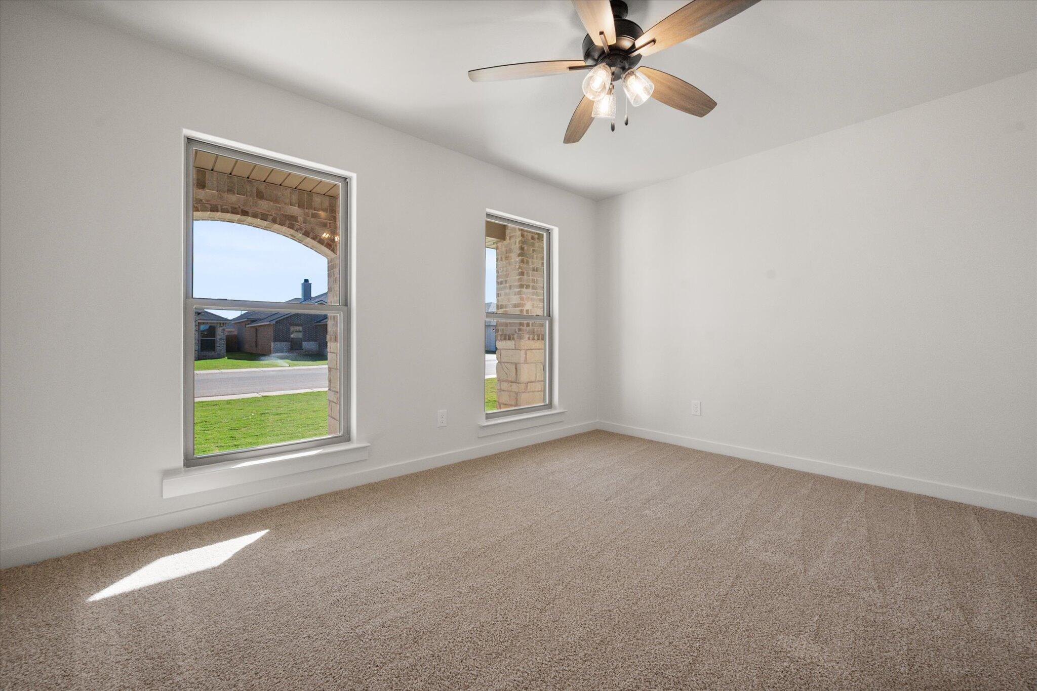 7004 16th Street Lubbock, TX 79416 - Photo 19 of 25 an empty room with windows and fan