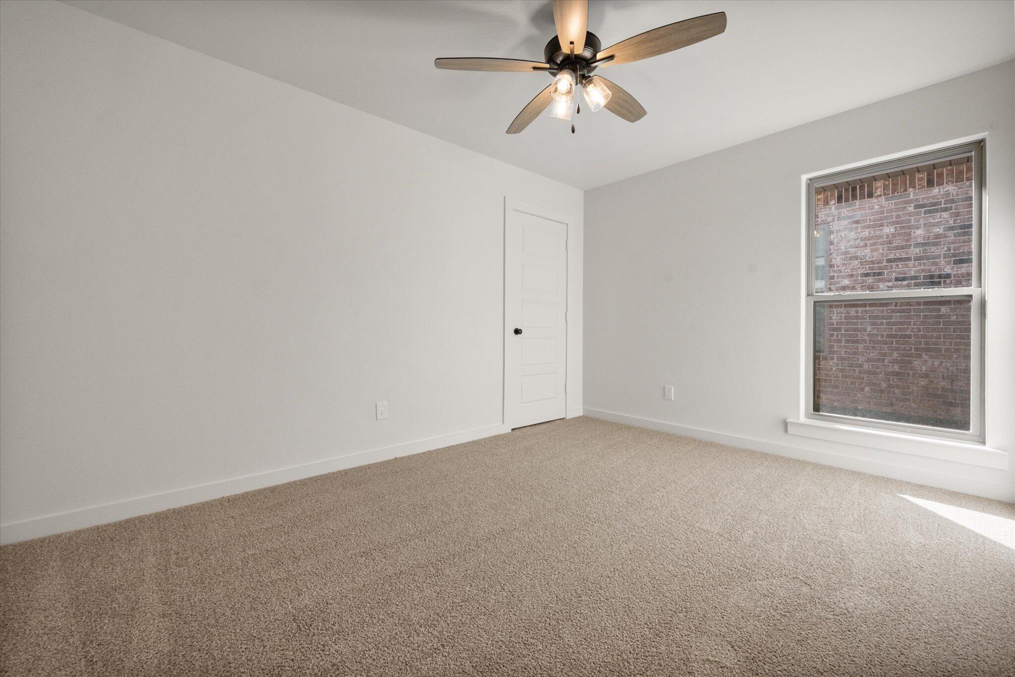 7004 16th Street Lubbock, TX 79416 - Photo 20 of 25 an empty room with a chandelier fan and windows