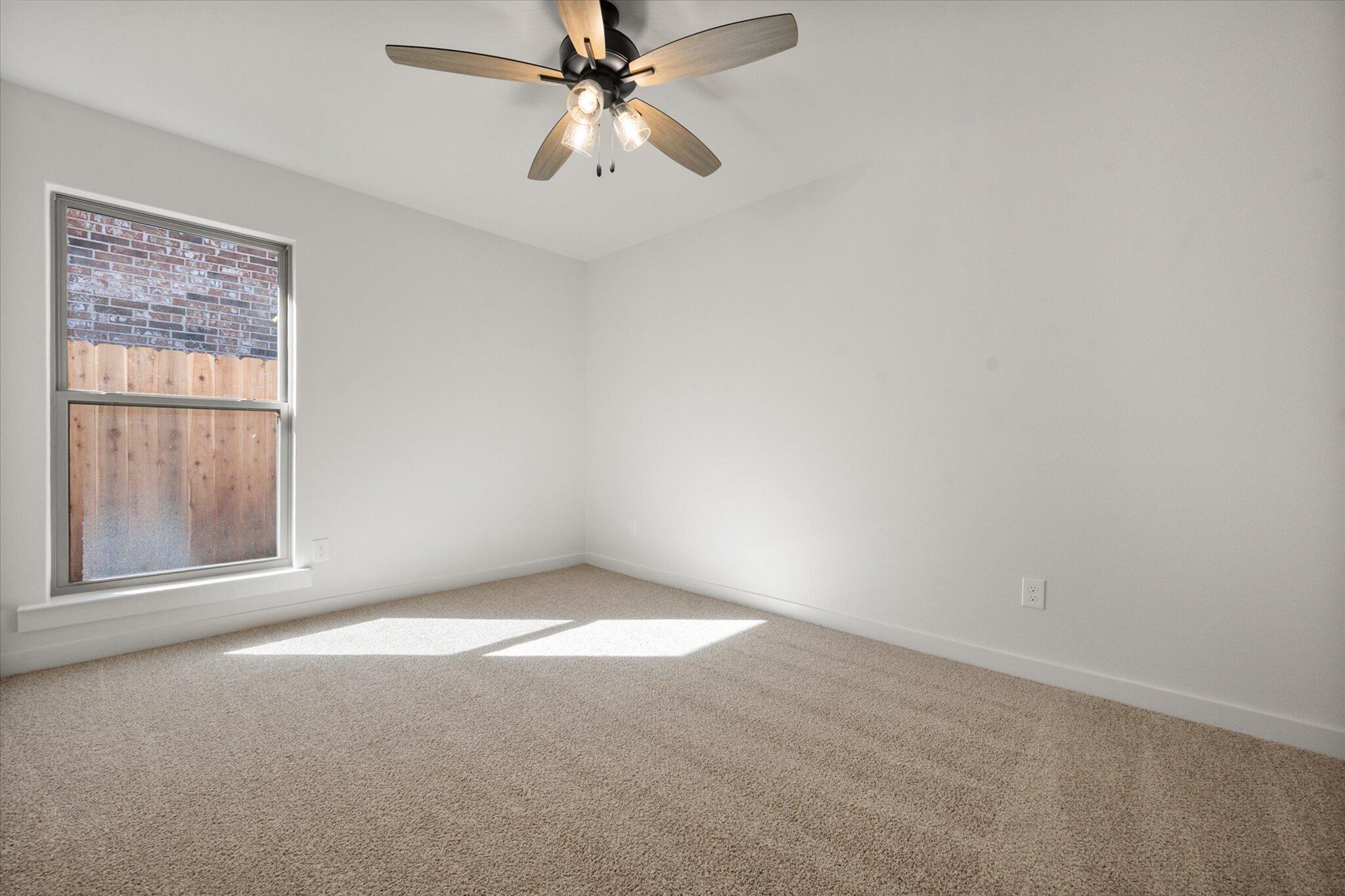 7004 16th Street Lubbock, TX 79416 - Photo 21 of 25 an empty room with a window and a fan