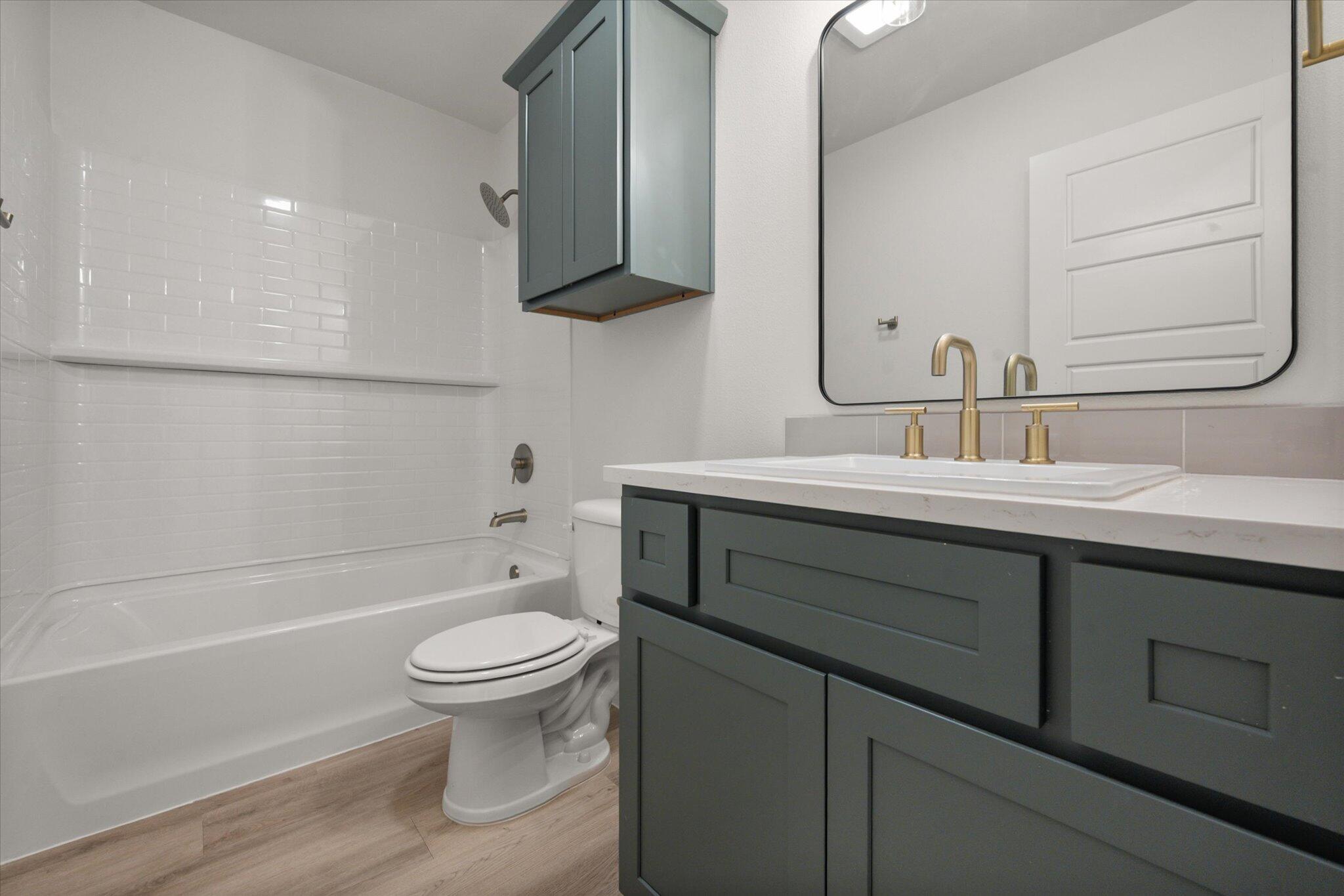 7004 16th Street Lubbock, TX 79416 - Photo 22 of 25 a bathroom with a sink a toilet and a bathtub