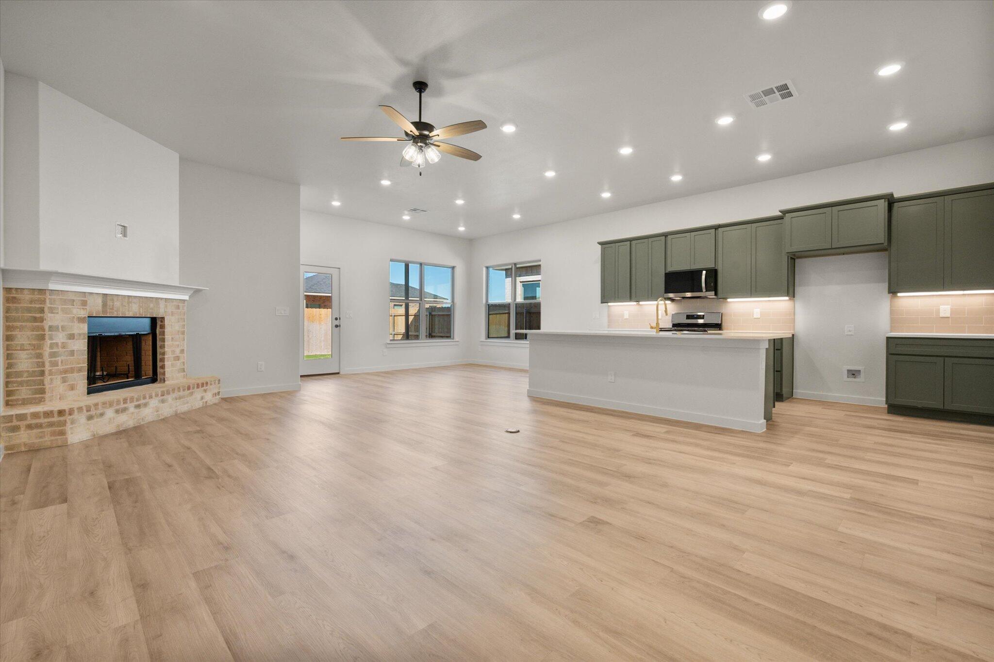 7004 16th Street Lubbock, TX 79416 - Photo 3 of 25 a view of a kitchen with a stove cabinets potted plants and wooden floor