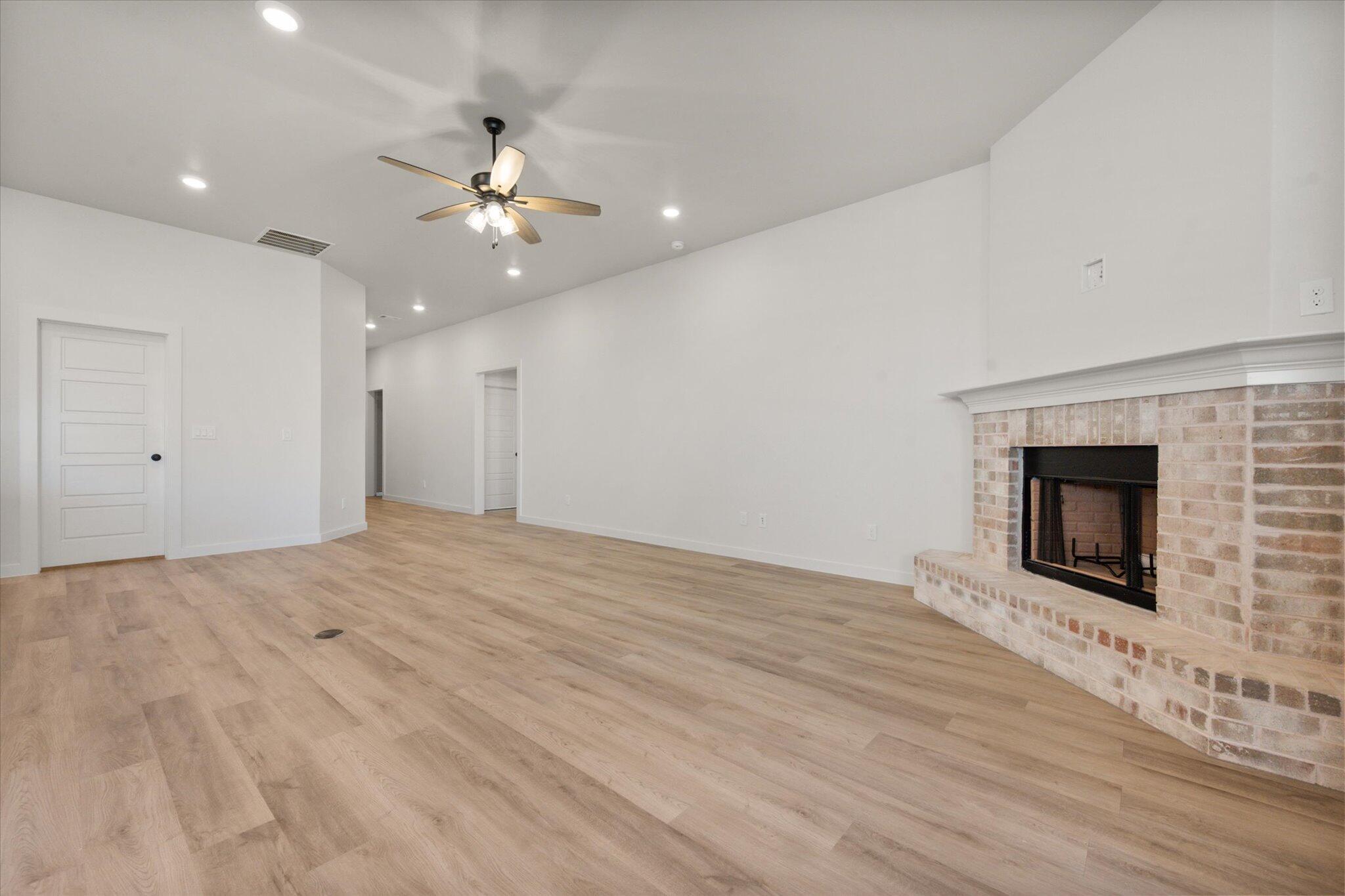 7004 16th Street Lubbock, TX 79416 - Photo 5 of 25 a view of empty room with wooden floor and fireplace