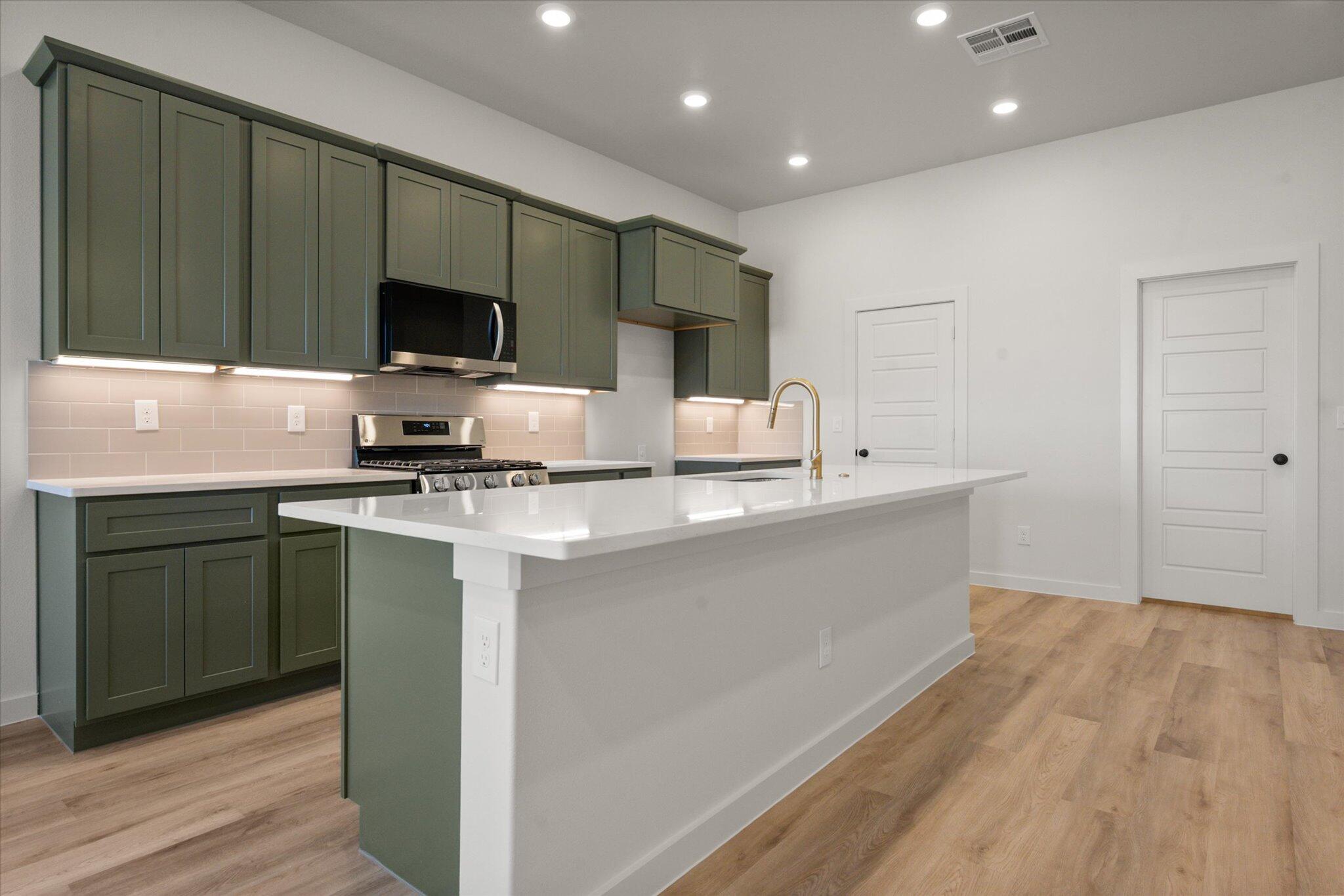7004 16th Street Lubbock, TX 79416 - Photo 7 of 25 a kitchen with stainless steel appliances kitchen island granite countertop a sink and a microwave