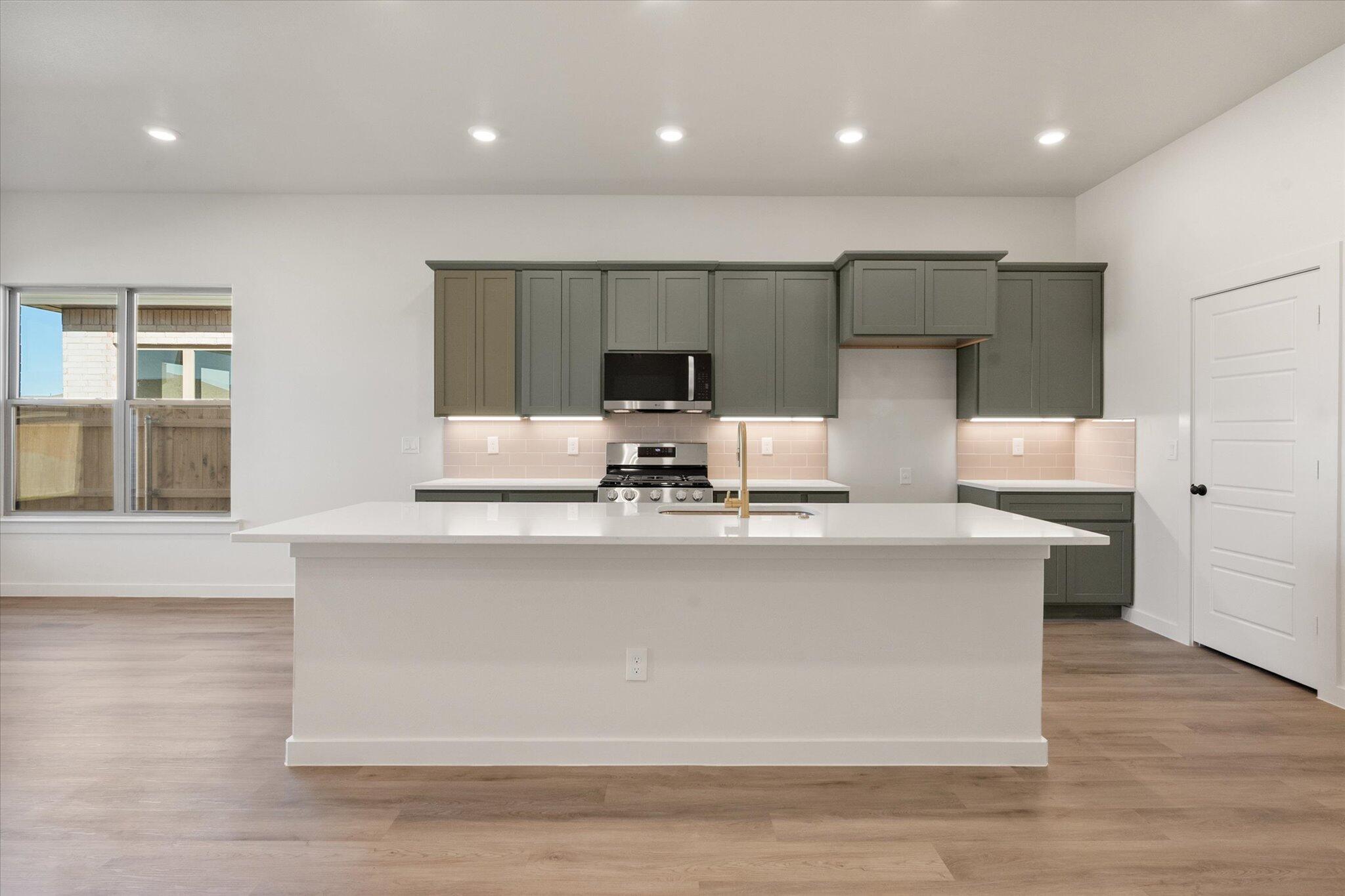 7004 16th Street Lubbock, TX 79416 - Photo 8 of 25 a dining hall with stainless steel appliances granite countertop a stove a sink and a microwave