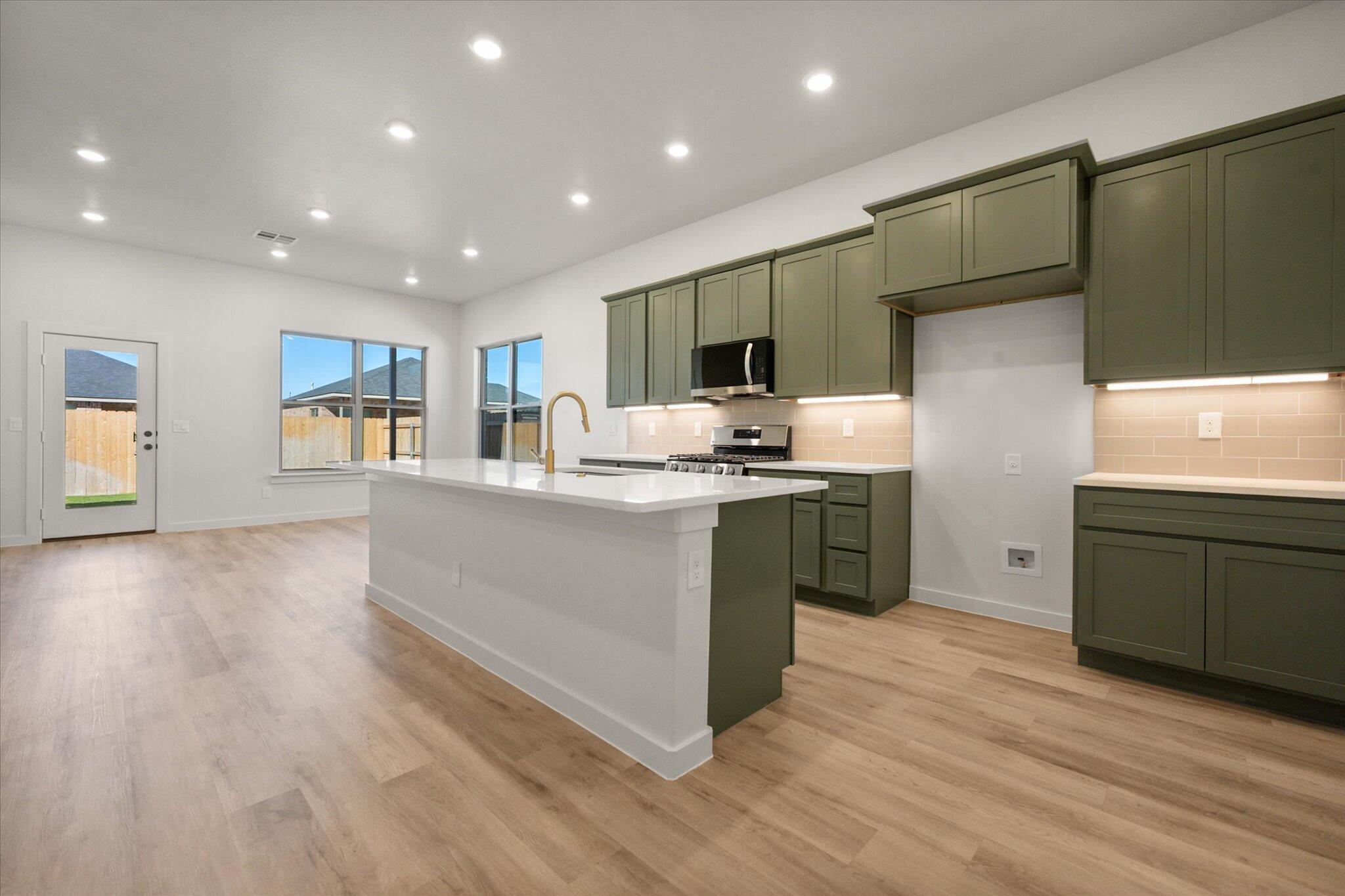 7004 16th Street Lubbock, TX 79416 - Photo 9 of 25 a large kitchen with stainless steel appliances granite countertop a stove a sink and a refrigerator