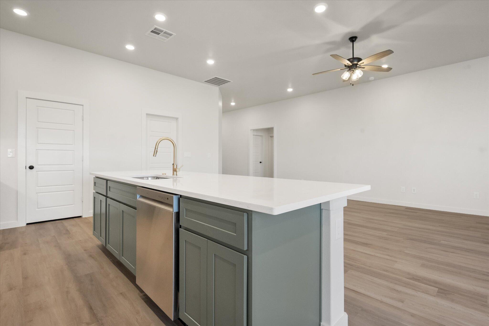7004 16th Street Lubbock, TX 79416 - Photo 10 of 25 a kitchen with a sink cabinets and wooden floor