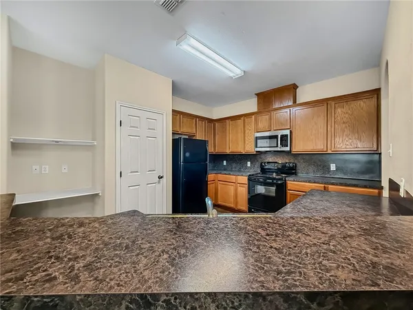 a kitchen with stainless steel appliances granite countertop a refrigerator stove top oven and sink