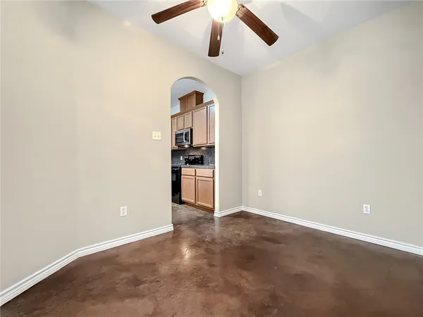 an empty room with kitchen and stainless steel appliances