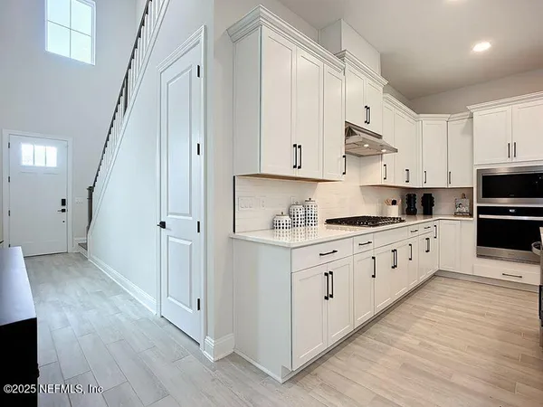 a kitchen with granite countertop white cabinets and white appliances