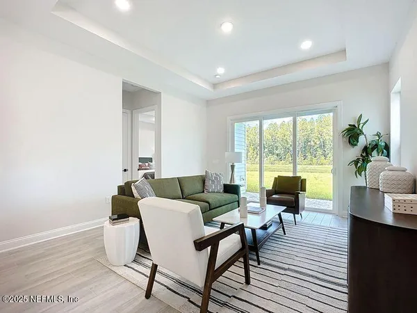 a living room with furniture and a floor to ceiling window