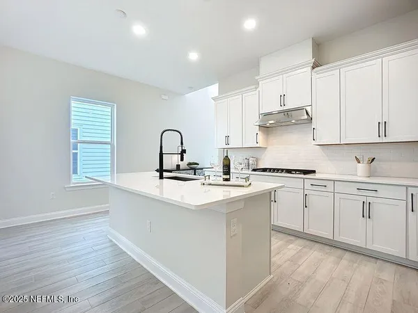 a kitchen with sink stove and cabinets