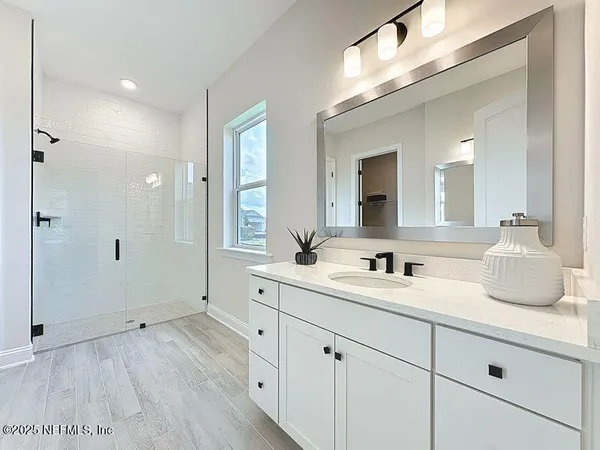 a spacious bathroom with a granite countertop sink mirror and shower