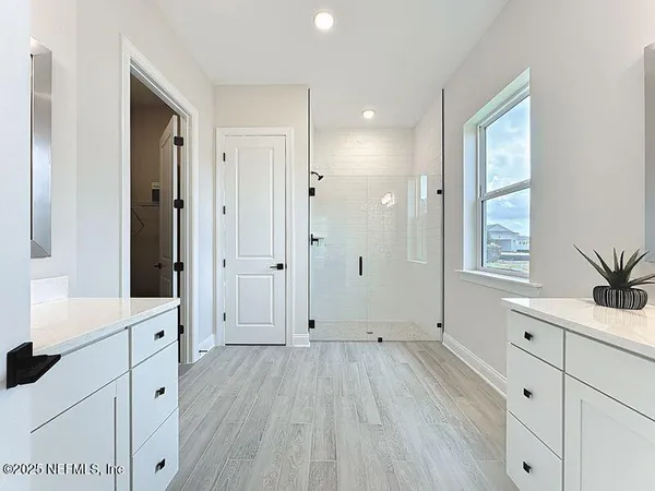 a view of a hallway with wooden floors and cabinet