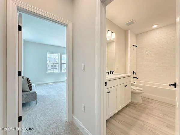 a bathroom with a granite countertop sink mirror and a bathtub