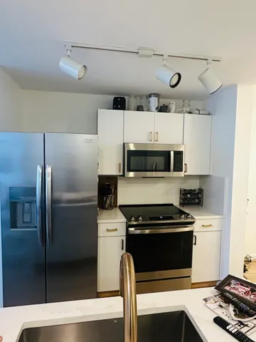 a dining room with wooden floor a chandelier a wooden table and chairs