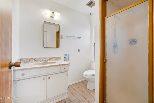a bathroom with a granite countertop sink toilet and shower
