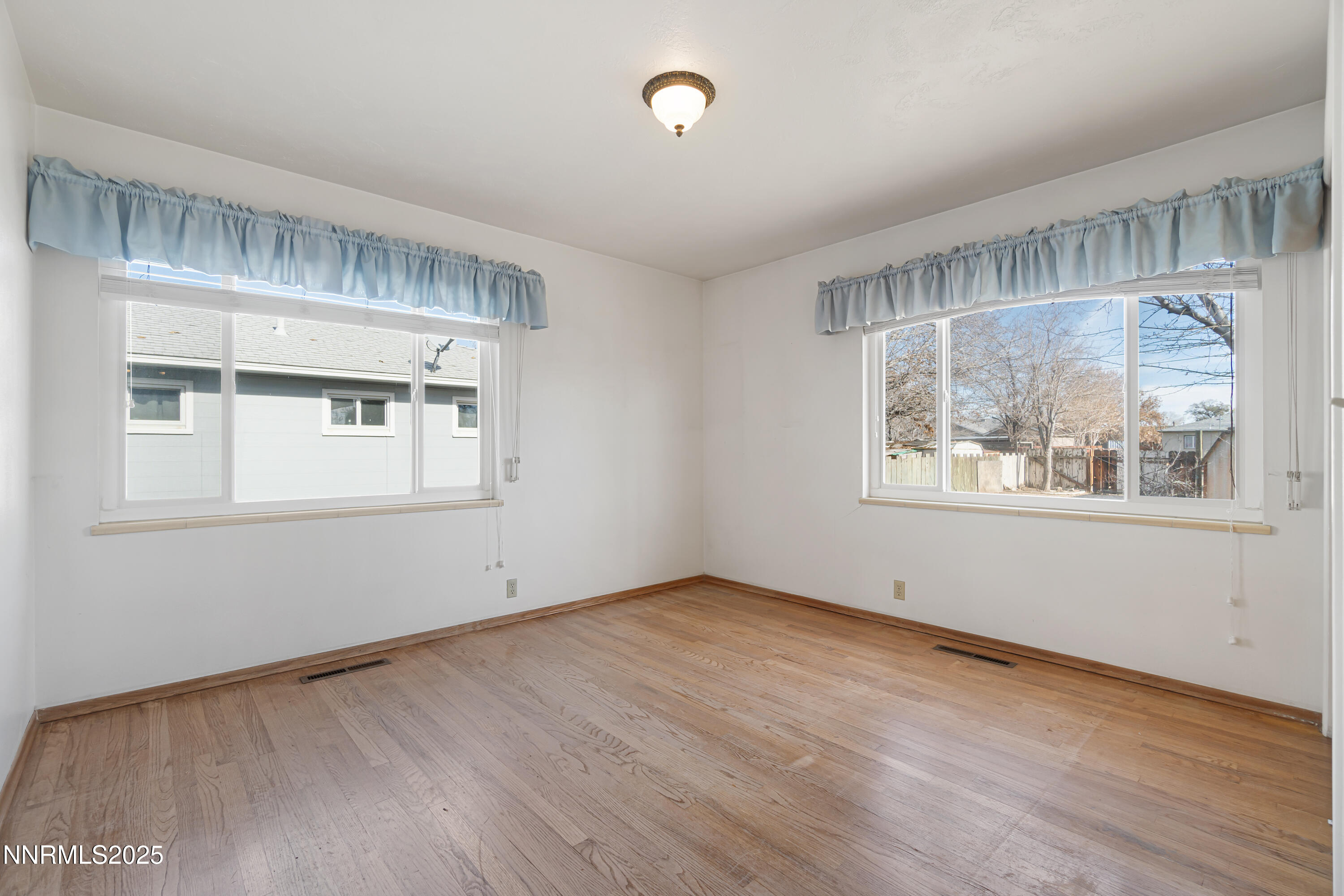 475 South Bailey Street Fallon, NV 89406 - Photo 19 of 27 an empty room with wooden floor and windows