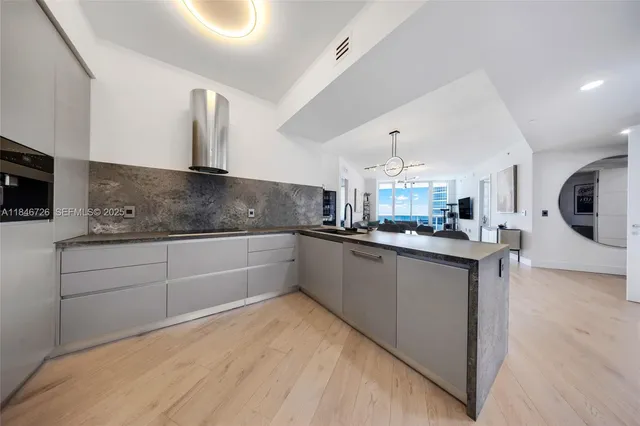 a kitchen with stainless steel appliances kitchen island granite countertop a refrigerator and a stove top oven