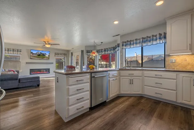 a kitchen with granite countertop white cabinets stainless steel appliances and sink