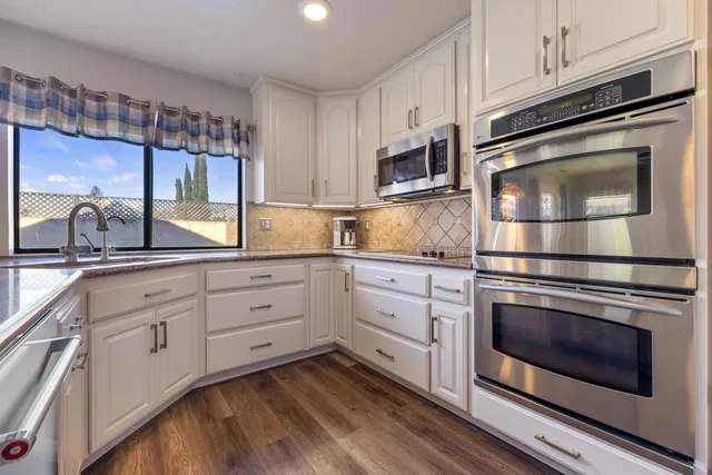 a kitchen with stainless steel appliances a refrigerator and a stove top oven