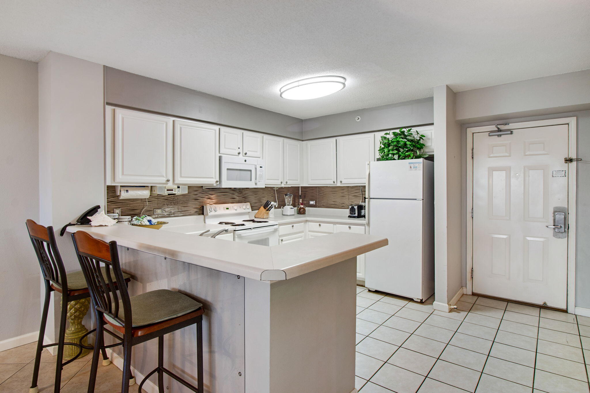 970 Highway 98, Unit 303 Destin, FL 32541 - Photo 13 of 42 a kitchen with a sink a refrigerator and cabinets