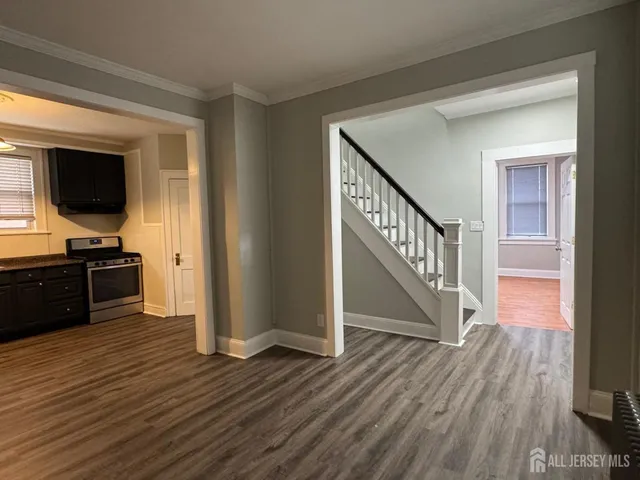 a view of a livingroom with wooden floor and staircase