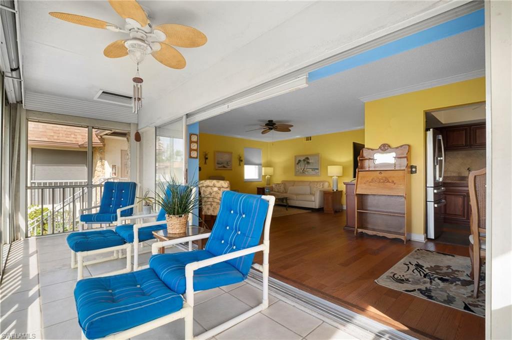 1155 Sandpiper Street, Unit G2 Naples, FL 34102 - Photo 2 of 8 a living room with couches and kitchen view with wooden floor