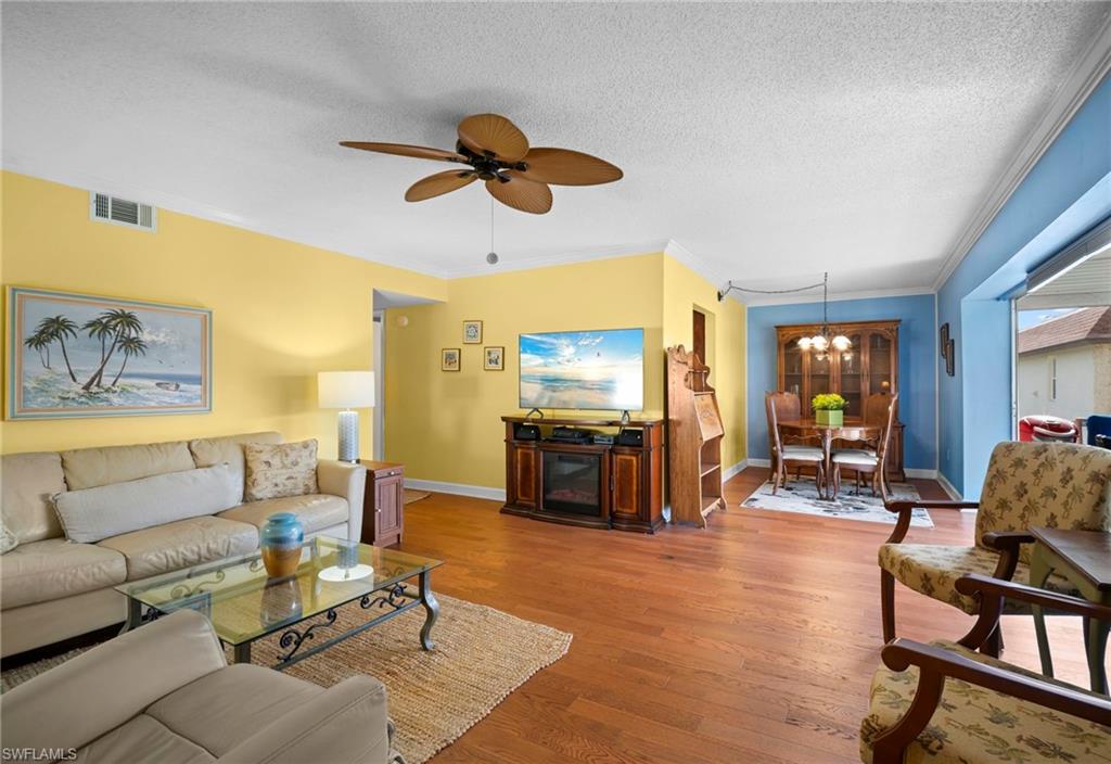 1155 Sandpiper Street, Unit G2 Naples, FL 34102 - Photo 3 of 8 a living room with furniture and a flat screen tv with wooden floor