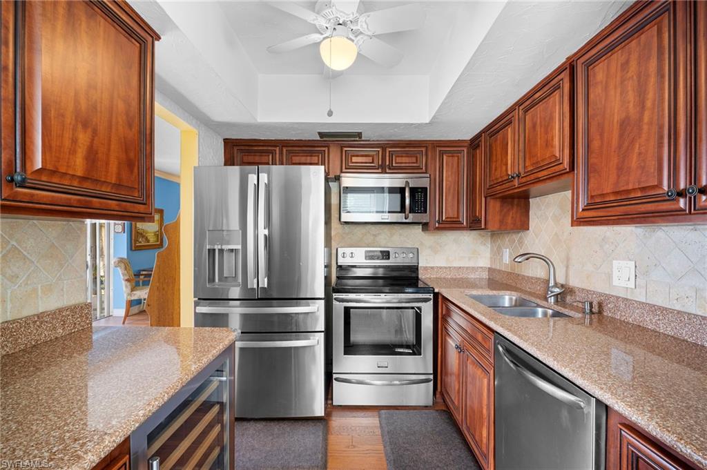 1155 Sandpiper Street, Unit G2 Naples, FL 34102 - Photo 4 of 8 a kitchen with stainless steel appliances granite countertop a refrigerator and a sink