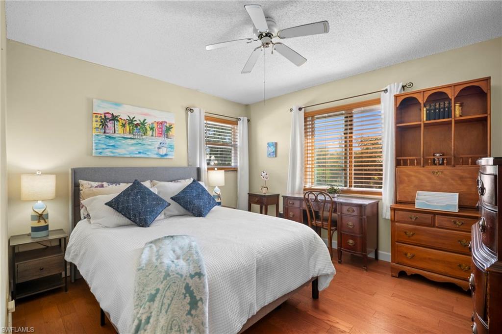 1155 Sandpiper Street, Unit G2 Naples, FL 34102 - Photo 7 of 8 a bedroom with a bed and a chandelier