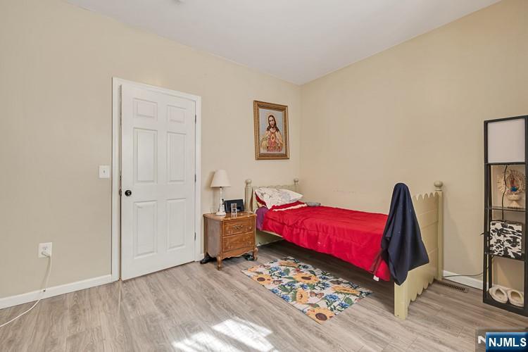 321 Grove Street Bloomfield, NJ 07017 - Photo 6 of 22 a bedroom with a bed and a potted plant on dresser