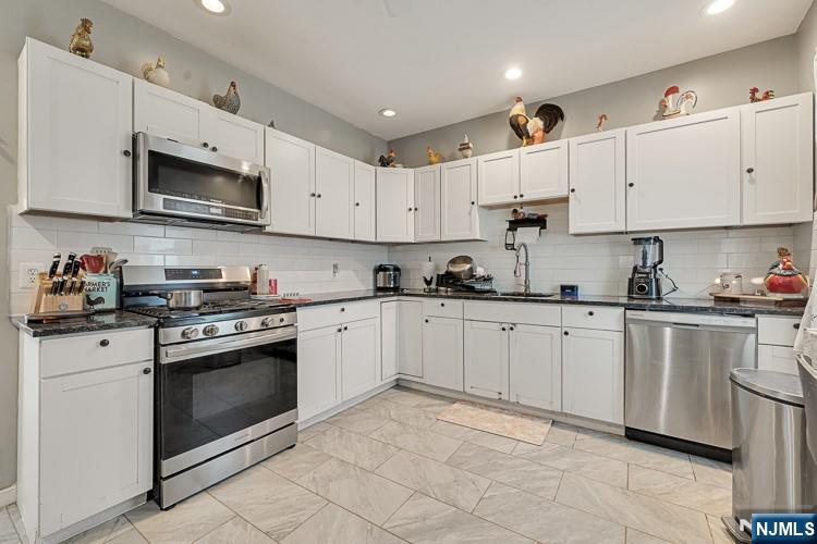 321 Grove Street Bloomfield, NJ 07017 - Photo 9 of 22 a kitchen with cabinets stainless steel appliances and sink