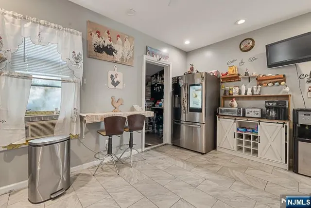 a kitchen with stainless steel appliances kitchen island granite countertop a refrigerator and a stove top oven