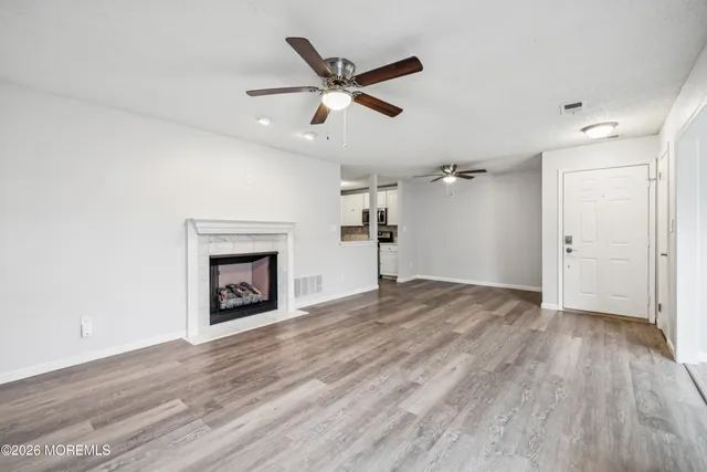 a view of a livingroom with a ceiling fan a fireplace and a ceiling fan