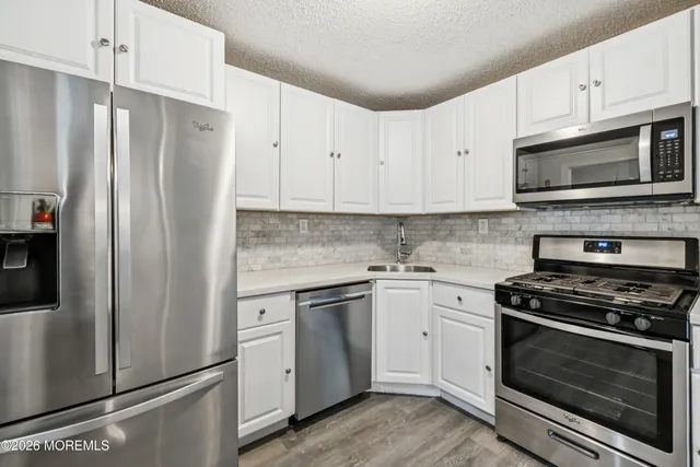 a kitchen with cabinets stainless steel appliances and a counter space