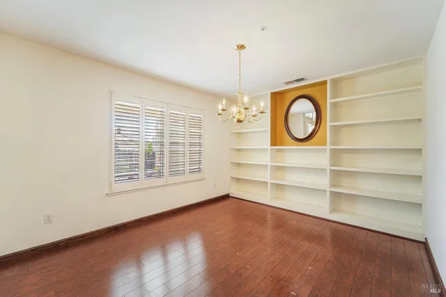 an empty room with a window and a fan