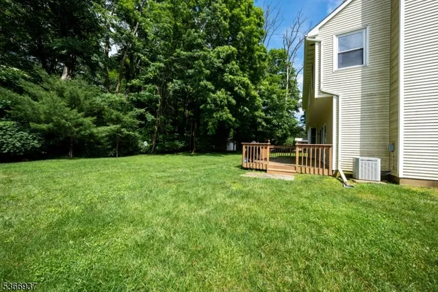 a front view of a house with a garden and trees