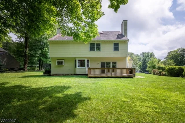a view of a house with backyard and a tree