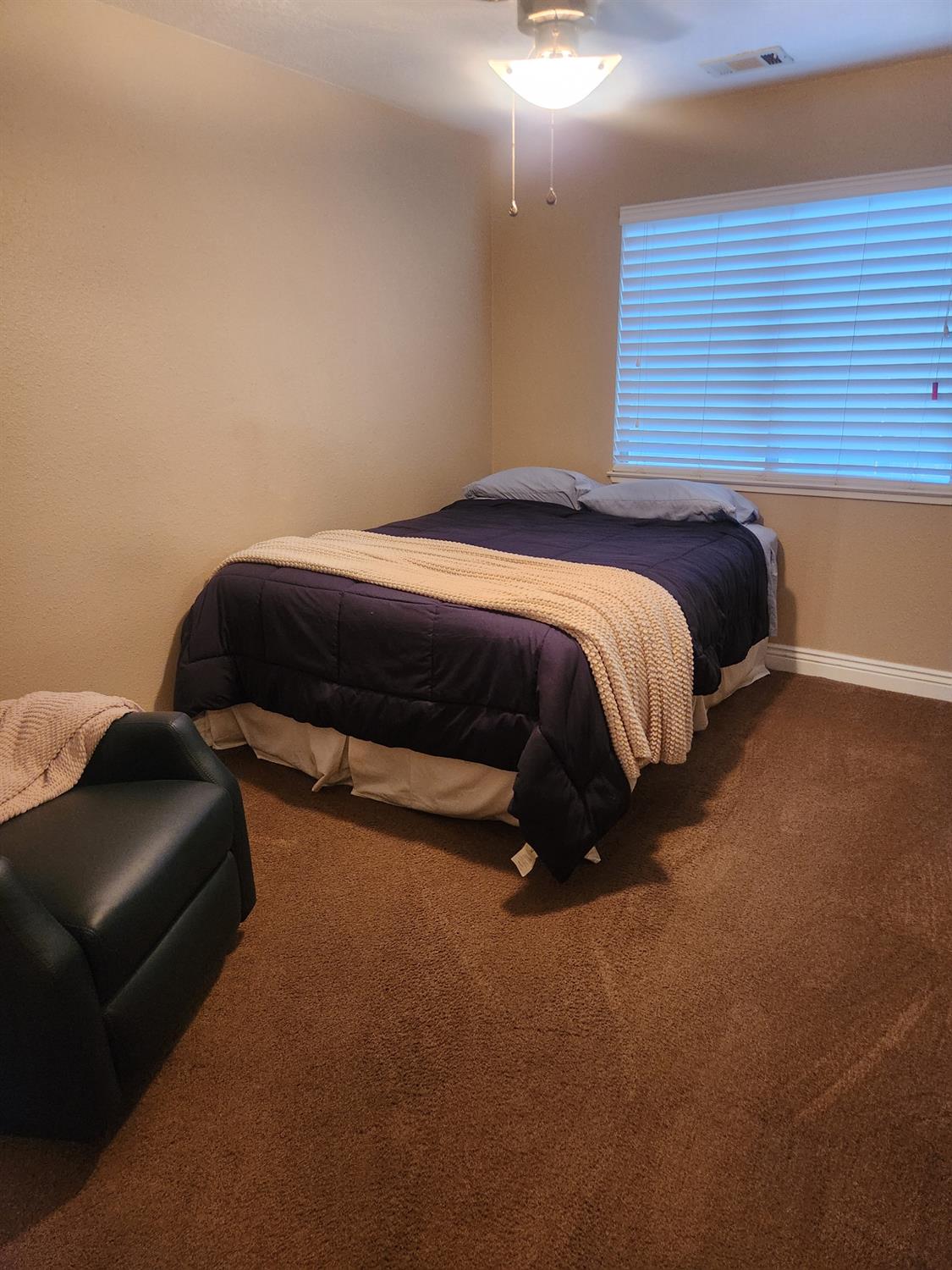 777 Jordanolo Drive Ripon, CA 95366 - Photo 35 of 61 a spacious bedroom with a bed and a couch