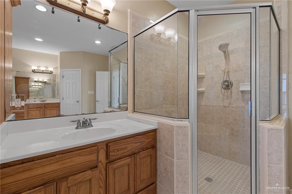 112 Madelyn Rose Bayview, TX 78566 - Photo 18 of 41 a bathroom with a shower sink vanity and mirror