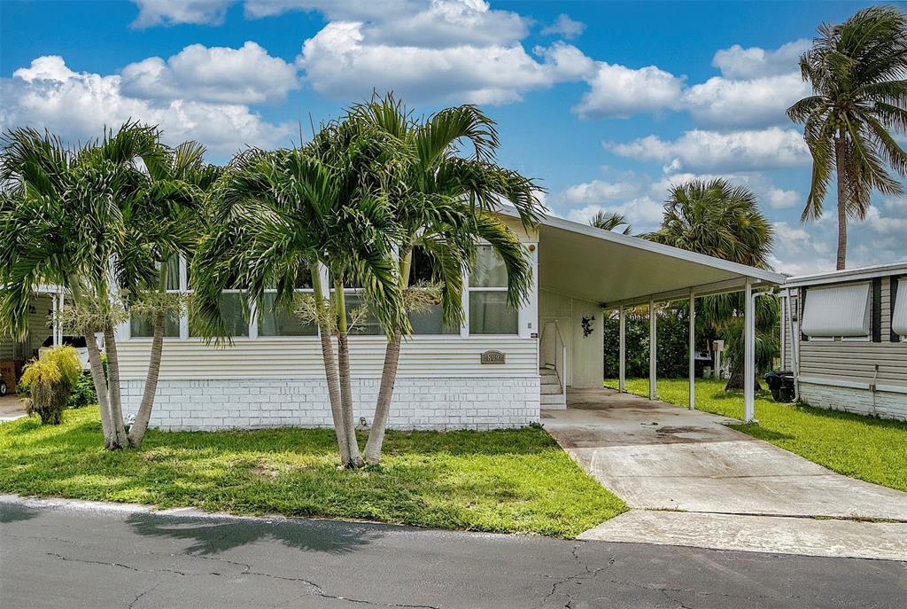 809 Putter Place Pompano Beach, FL 33069 - Photo 3 of 51 a front view of a house with a garden