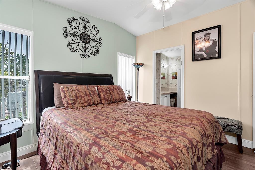 809 Putter Place Pompano Beach, FL 33069 - Photo 32 of 51 a large bed in a bedroom next to a window with a chandelier