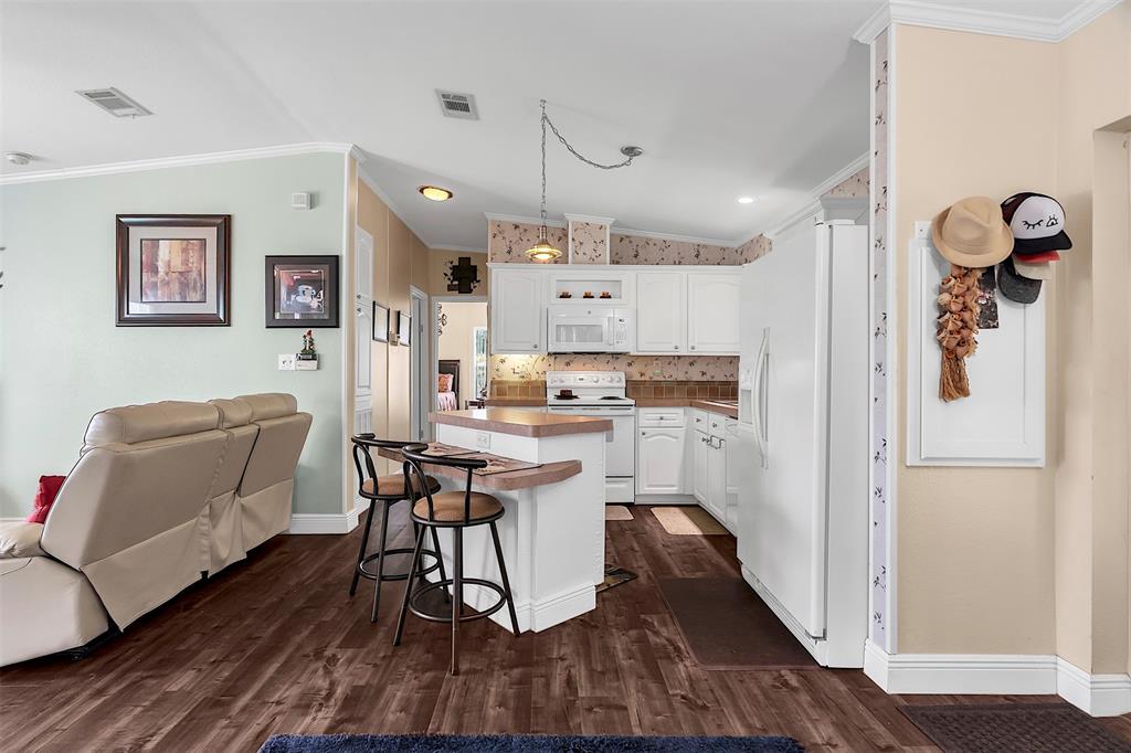 809 Putter Place Pompano Beach, FL 33069 - Photo 7 of 51 a kitchen with a refrigerator a white table and chairs