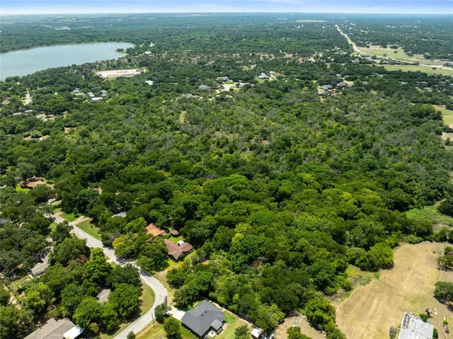 an aerial view of residential houses with outdoor space and trees