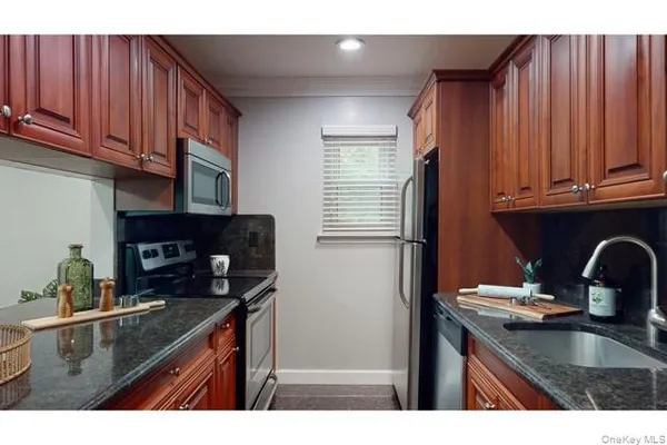 a kitchen with granite countertop a sink stove and cabinets